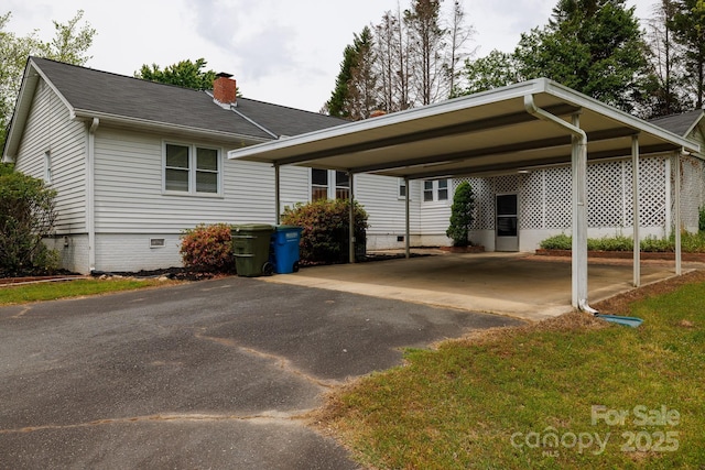 view of front facade featuring crawl space, driveway, and a chimney