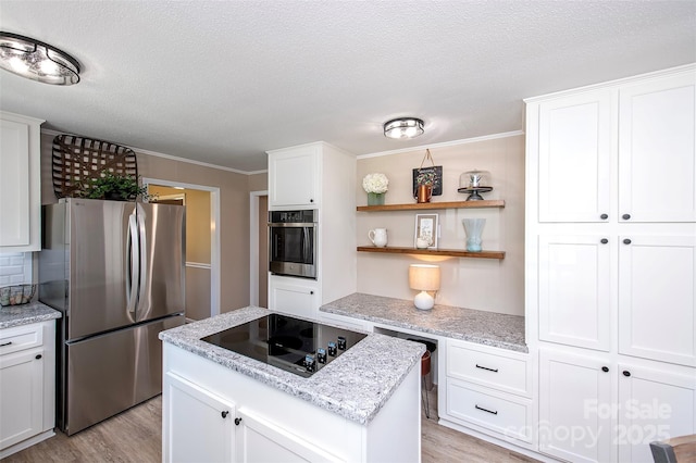 kitchen with a kitchen island, light wood finished floors, a textured ceiling, and appliances with stainless steel finishes