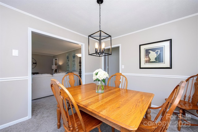 carpeted dining space featuring baseboards, a chandelier, and crown molding