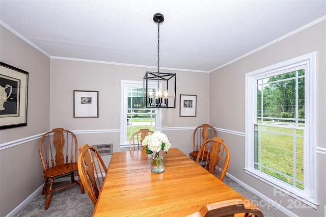 carpeted dining room featuring ornamental molding, baseboards, and a notable chandelier