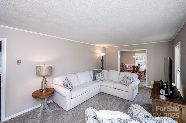 living area with ornamental molding, baseboards, a textured ceiling, carpet flooring, and a notable chandelier