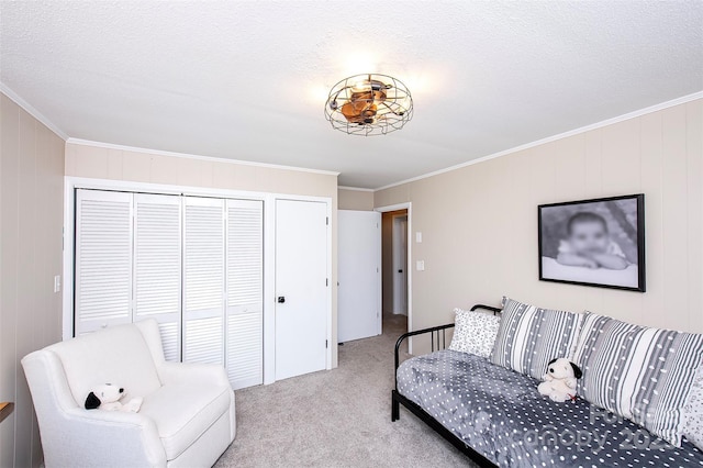 bedroom featuring carpet floors, ornamental molding, a textured ceiling, and a closet