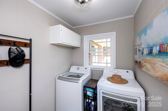laundry area with separate washer and dryer, a textured ceiling, ornamental molding, and cabinet space