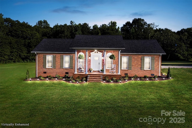 view of front facade with crawl space, covered porch, a front lawn, and brick siding