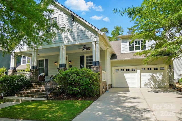view of front of property featuring covered porch, driveway, a garage, a shingled roof, and stairs