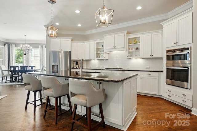 kitchen featuring an inviting chandelier, appliances with stainless steel finishes, ornamental molding, and a sink