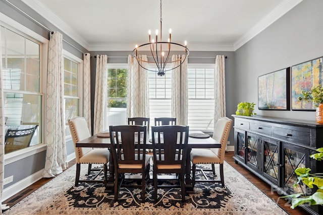 dining space featuring crown molding, baseboards, a chandelier, and a wealth of natural light