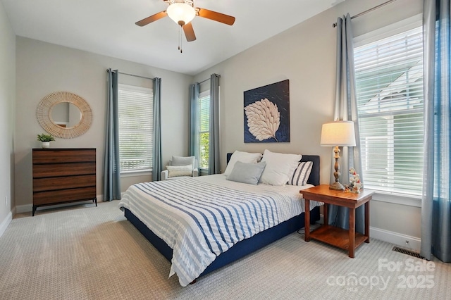 bedroom featuring baseboards, visible vents, a ceiling fan, and light colored carpet