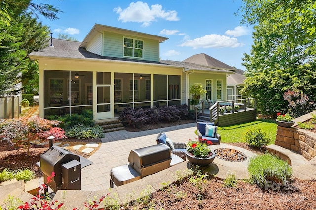 back of property with a sunroom, a shingled roof, ceiling fan, and a patio area