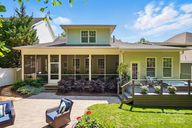 back of property featuring a sunroom, a shingled roof, fence, and a yard