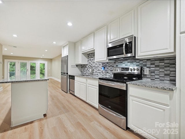 7004 Quail Hill Rd, Charlotte, NC 28210 - kitchen with light wood-type flooring, stainless steel appliances, decorative backsplash, and white cabinets