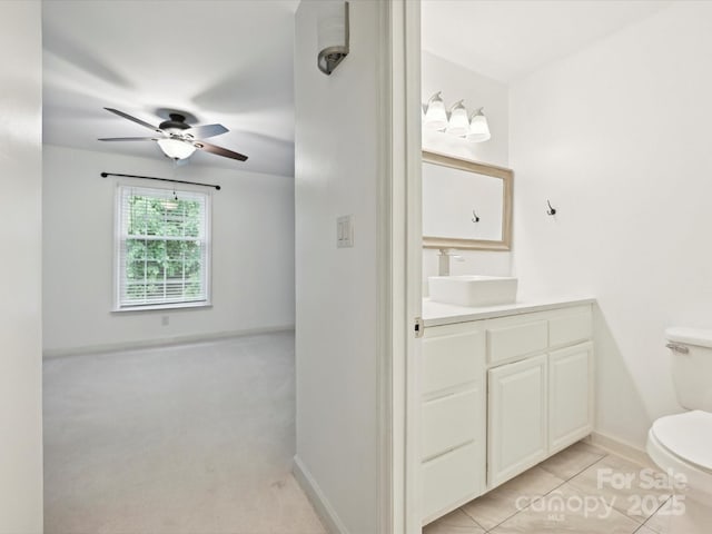 7004 Quail Hill Rd, Charlotte, NC 28210 - half bath with tile patterned flooring, toilet, vanity, baseboards, and a ceiling fan