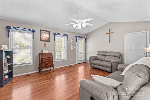 living room featuring lofted ceiling, plenty of natural light, light wood-type flooring, and ceiling fan