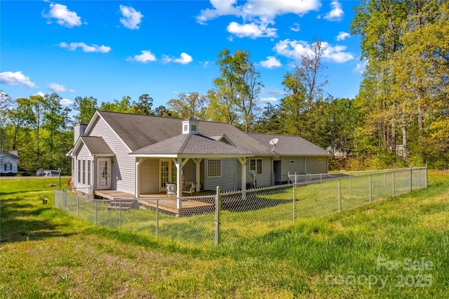 back of house featuring a yard, a chimney, and a fenced backyard