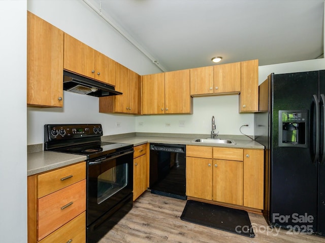 1611 Central Ave Unit 406, Charlotte, NC 28205 - kitchen with a sink, under cabinet range hood, light wood-type flooring, black appliances, and light countertops