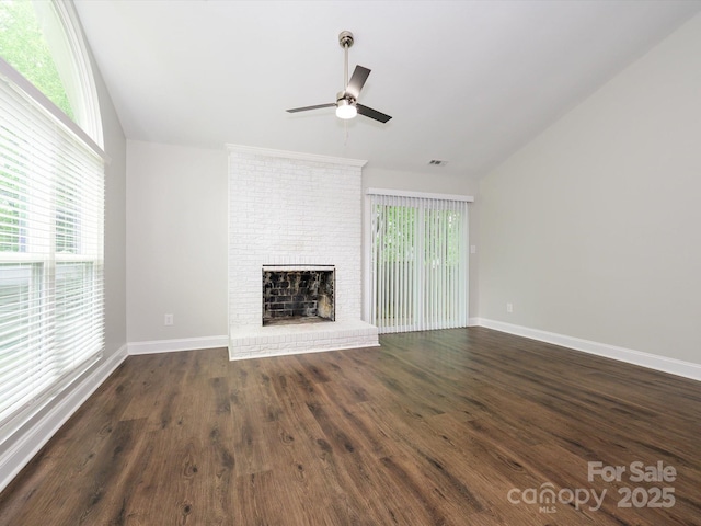 unfurnished living room with lofted ceiling, visible vents, a ceiling fan, a brick fireplace, and dark wood-style flooring