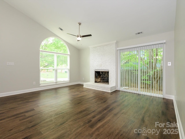 unfurnished living room with dark wood finished floors, vaulted ceiling, a ceiling fan, and a healthy amount of sunlight