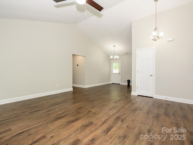unfurnished room featuring ceiling fan with notable chandelier, baseboards, dark wood-type flooring, and lofted ceiling