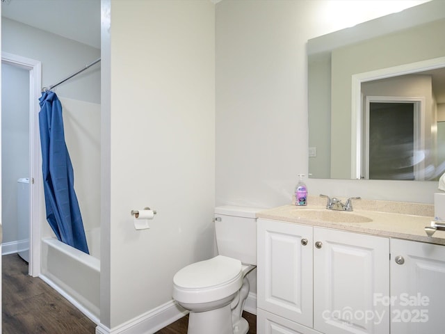 bathroom with wood finished floors, vanity, baseboards, shower / tub combo, and toilet