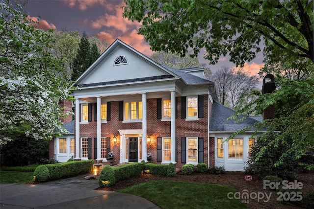 6824 N Baltusrol Ln, Charlotte, NC 28210 - greek revival house featuring brick siding, roof with shingles, a chimney, and covered porch