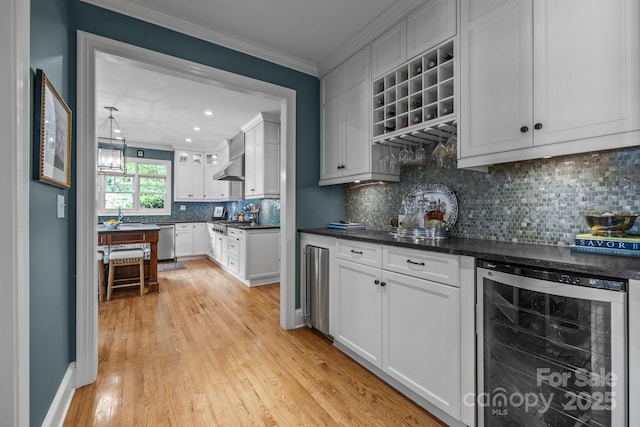 6824 N Baltusrol Ln, Charlotte, NC 28210 - kitchen with beverage cooler, stainless steel dishwasher, crown molding, dark countertops, and light wood-style flooring