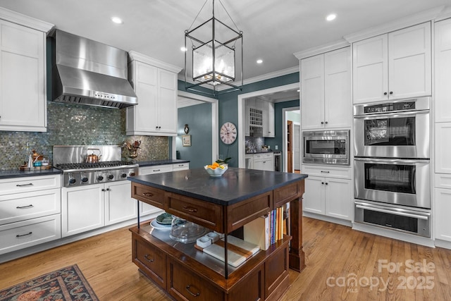 6824 N Baltusrol Ln, Charlotte, NC 28210 - kitchen with wall chimney range hood, stainless steel appliances, a warming drawer, dark countertops, and a chandelier