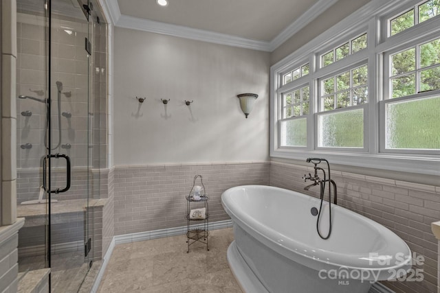 6824 N Baltusrol Ln, Charlotte, NC 28210 - bathroom featuring a stall shower, a freestanding bath, wainscoting, ornamental molding, and tile walls