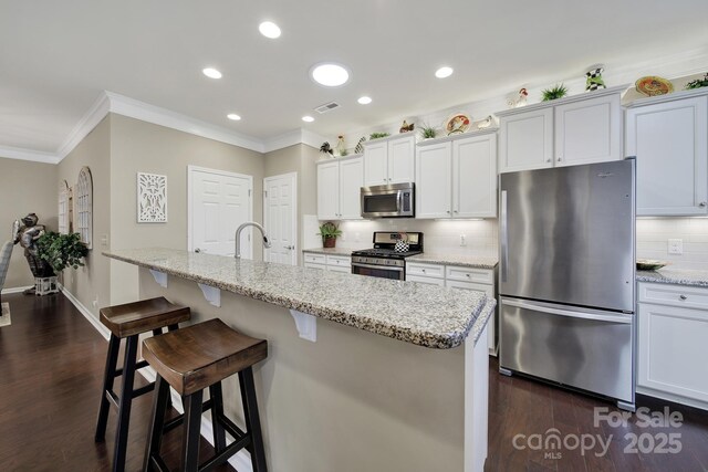 kitchen featuring decorative backsplash, visible vents, crown molding, and stainless steel appliances