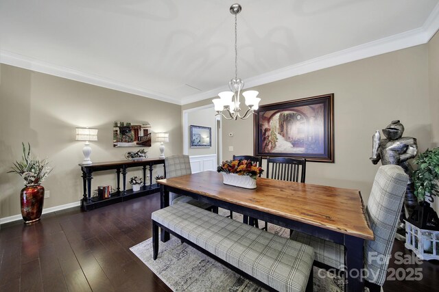 dining space featuring wood finished floors, crown molding, baseboards, and an inviting chandelier