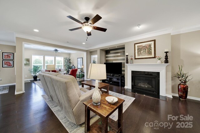 living room with ceiling fan, baseboards, crown molding, and wood finished floors