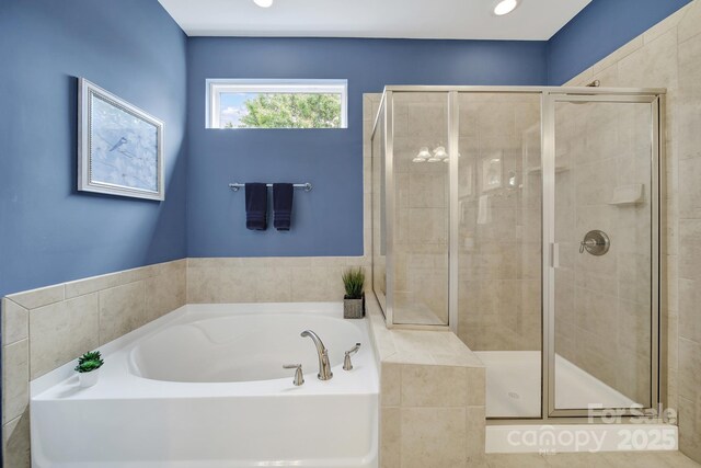 bathroom featuring a shower stall and a garden tub