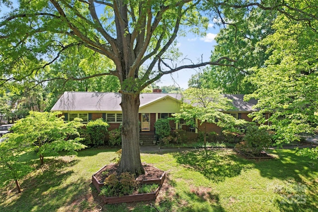 view of front facade featuring brick siding and a front yard