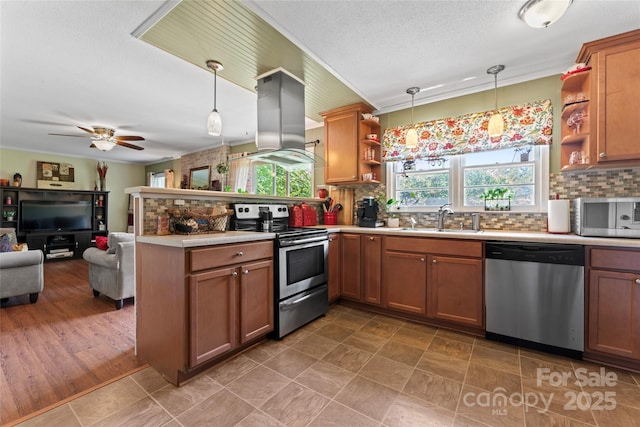 kitchen featuring open shelves, a sink, island exhaust hood, a peninsula, and appliances with stainless steel finishes