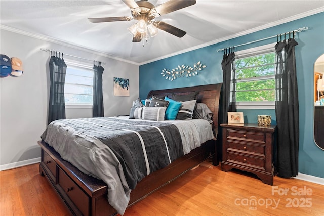 bedroom featuring baseboards, ornamental molding, multiple windows, and light wood-type flooring