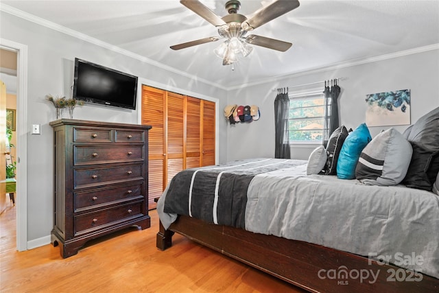 bedroom featuring ceiling fan, light wood-style flooring, a closet, and ornamental molding