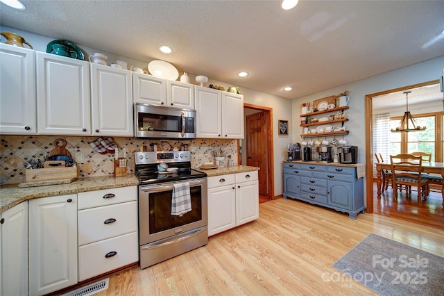 122 Roxboro Ct Unit 286, Mount Gilead, NC 27306 - kitchen with light wood-type flooring, white cabinets, and stainless steel appliances
