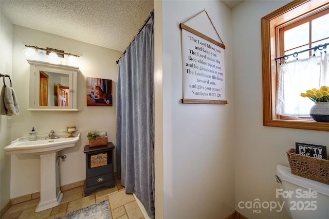 122 Roxboro Ct Unit 286, Mount Gilead, NC 27306 - full bath with curtained shower, toilet, baseboards, a textured ceiling, and a sink