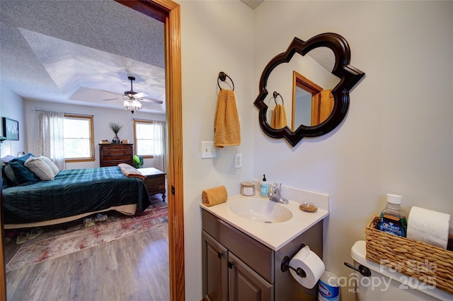 122 Roxboro Ct Unit 286, Mount Gilead, NC 27306 - bathroom with wood finished floors, connected bathroom, a textured ceiling, a tray ceiling, and a ceiling fan