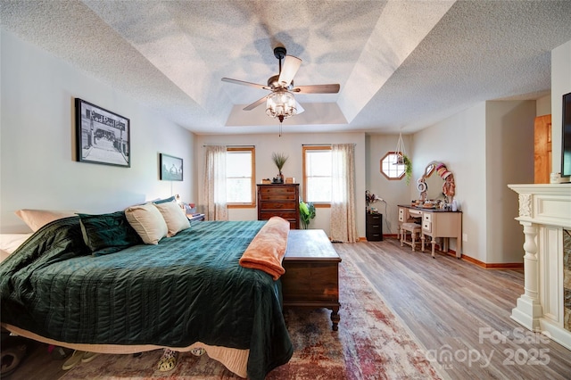 122 Roxboro Ct Unit 286, Mount Gilead, NC 27306 - bedroom with a ceiling fan, a textured ceiling, a raised ceiling, baseboards, and light wood-style floors