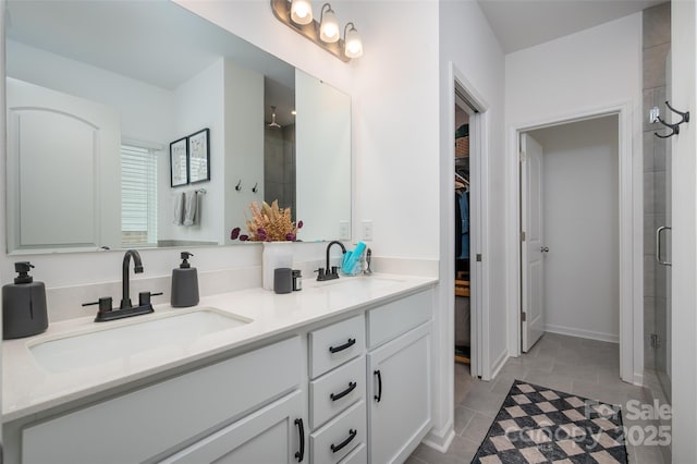 1024 Scotch Meadows Loop Unit 32, Monroe, NC 28110 - bathroom featuring a stall shower, a walk in closet, double vanity, and tile patterned floors