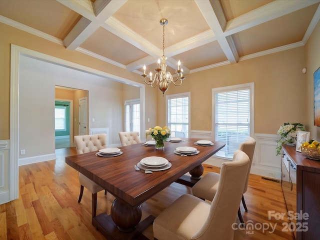 dining room with a wealth of natural light, light wood-style floors, and coffered ceiling