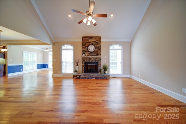 unfurnished living room featuring lofted ceiling, a stone fireplace, and ceiling fan with notable chandelier