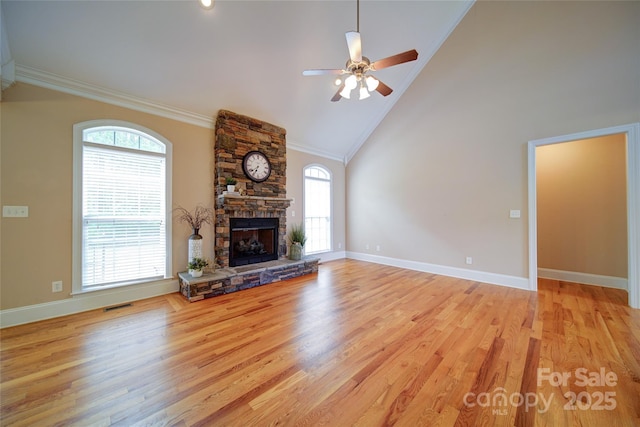 unfurnished living room with a fireplace, crown molding, ceiling fan, and a healthy amount of sunlight