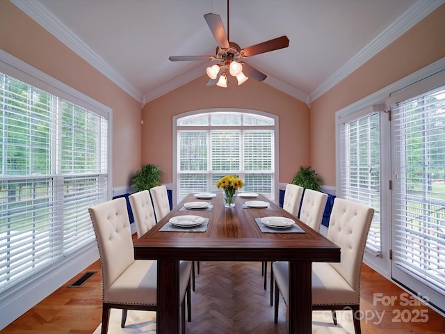 dining space with vaulted ceiling, visible vents, crown molding, and ceiling fan