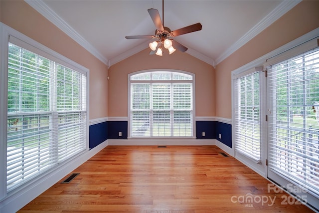 empty room with ceiling fan, ornamental molding, visible vents, and light wood-type flooring