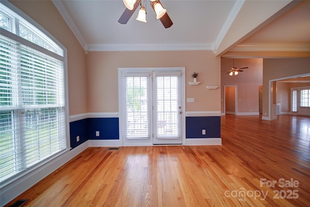 unfurnished room with ceiling fan, baseboards, ornamental molding, and light wood-style floors