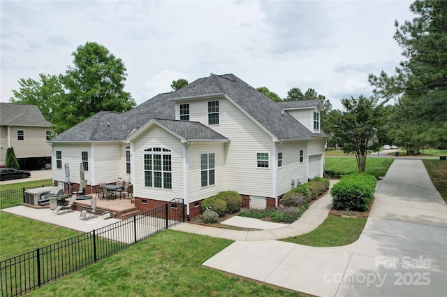 rear view of property featuring a yard, roof with shingles, and fence