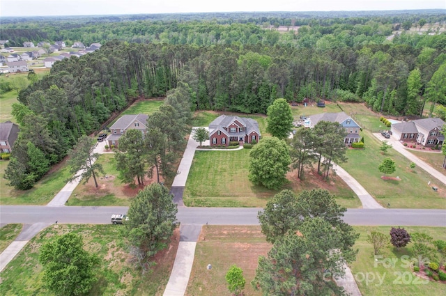 birds eye view of property with a view of trees and a residential view
