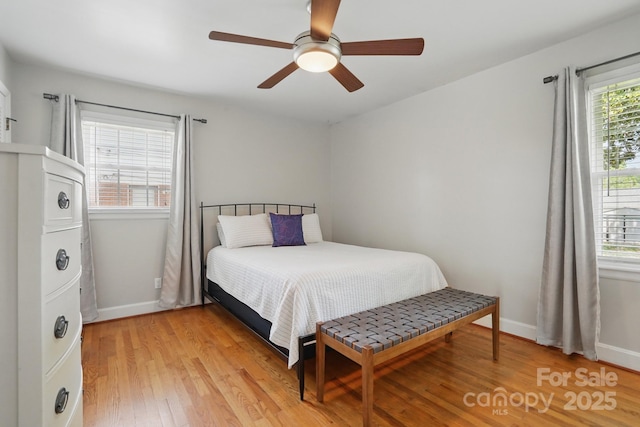 bedroom featuring light wood-type flooring, baseboards, and ceiling fan