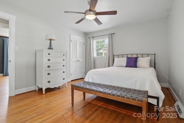 bedroom with light wood-style flooring, a closet, and baseboards